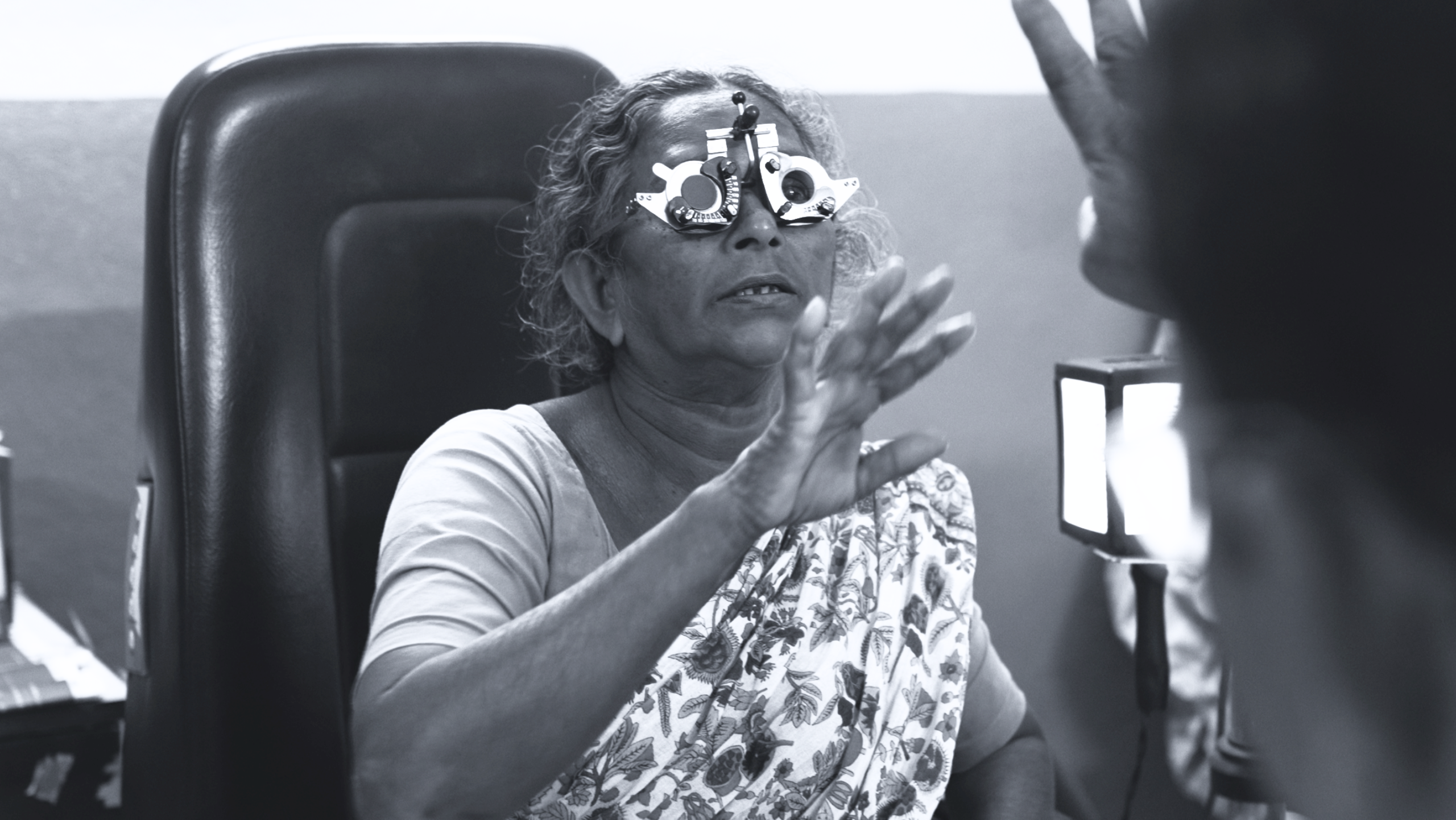 Elderly Indian woman wearing trial lens frames during an eye examination at Hand in Hand eye care program
