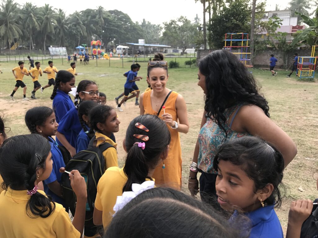 A visitor with schoolchildren during a Hand in Hand trip in India